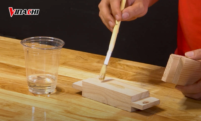 Trải đều keo lên bề mặt gỗ keo