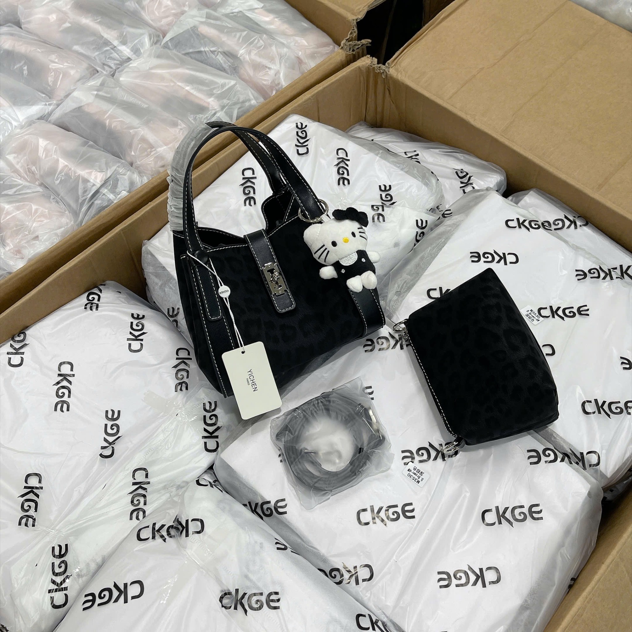 TUI ĐEN VIỀN CHỈ TRẮNG KÈM CHARM MÈO M265182