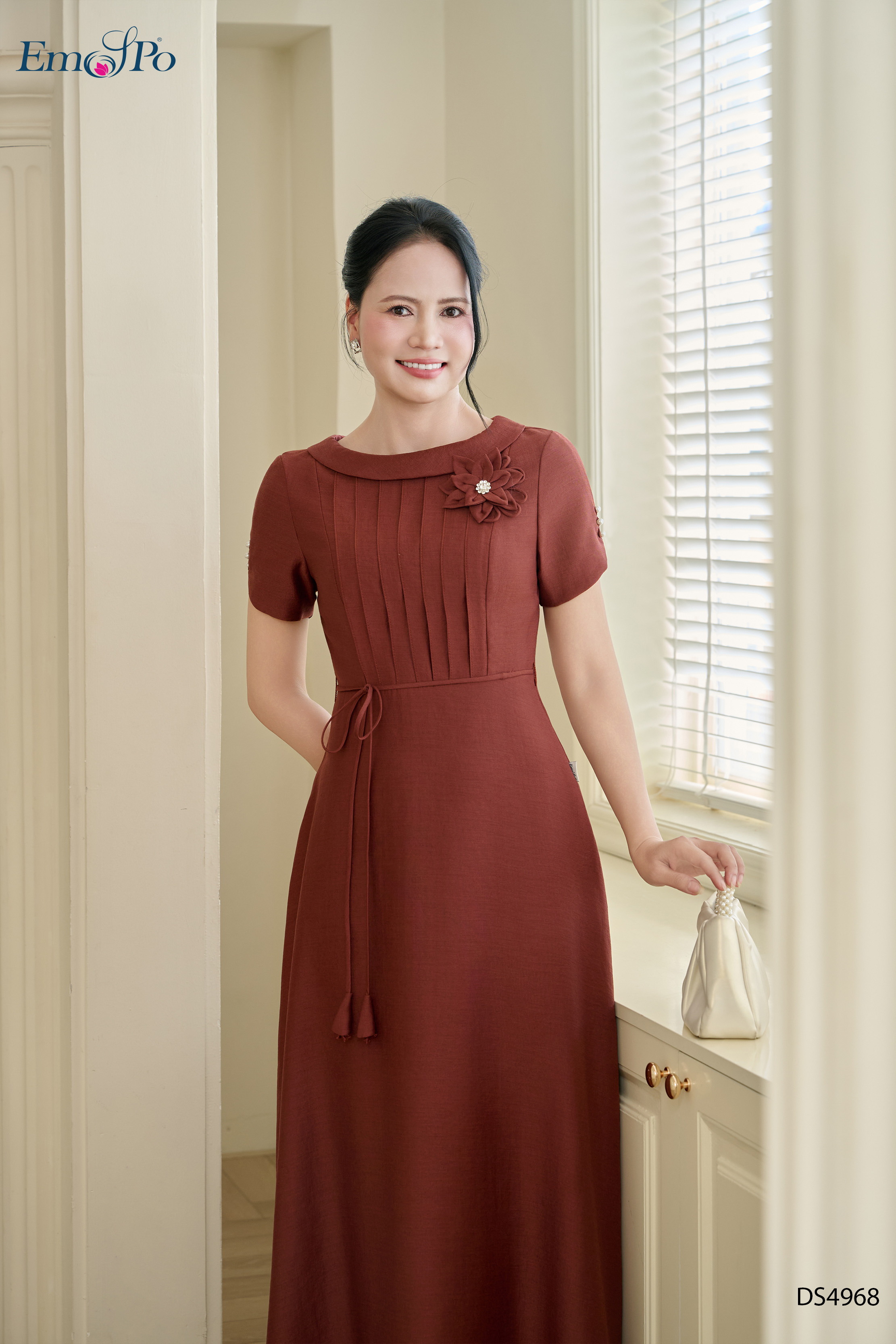 Đầm A xòe, cổ thuyền ngực xếp ly, hoa cài và dây hoa rời