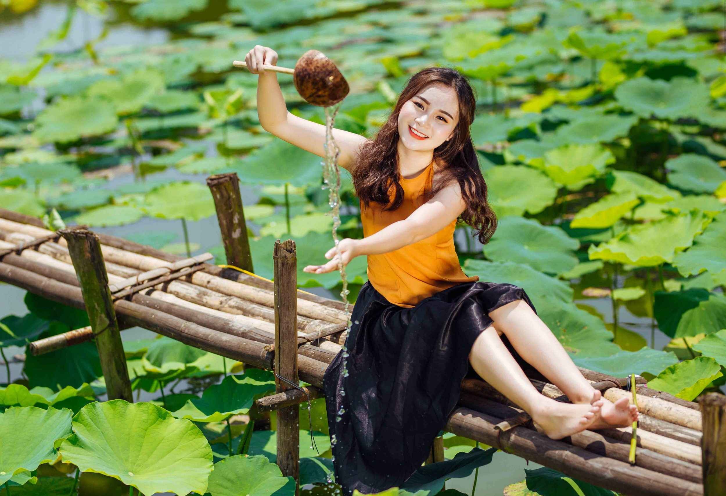 Tạo dáng chụp sen với tư thế nghịch nước bên ao