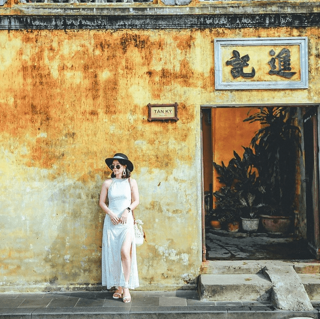 Tựa vai vào tường vàng tạo dáng thật đẹp