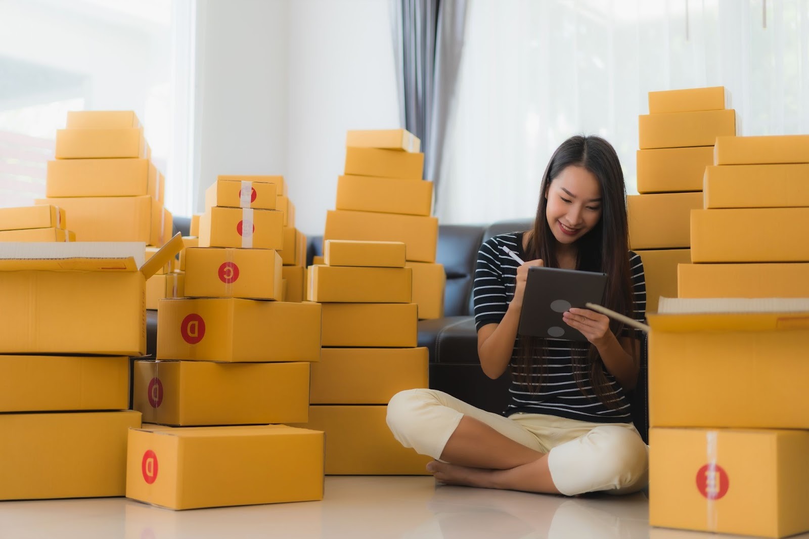 Nữ chủ shop ghi chép bên cạnh hàng nhập từ Trung Quốc