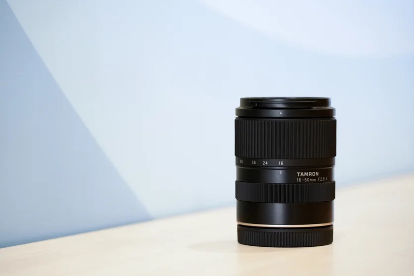 Ống kính Tamron 16-50mm F/2.8 A B091 đặt trên bàn làm việc nhỏ gọn