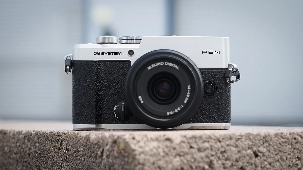 Máy ảnh OM System PEN gắn kèm ống kính M.Zuiko 14-42mm f/3.5-5.6 III trong môi trường đô thị