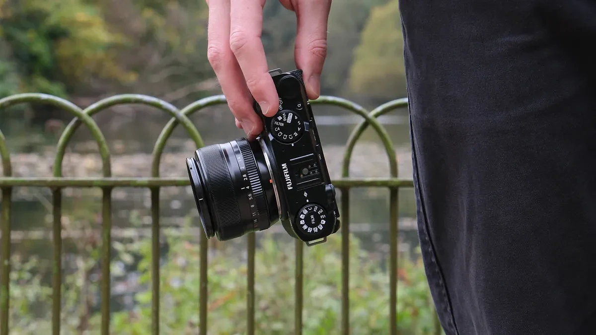 Máy ảnh Fujifilm X-M5 gắn ống kính 35mm cầm gọn trên tay tại bờ hồ