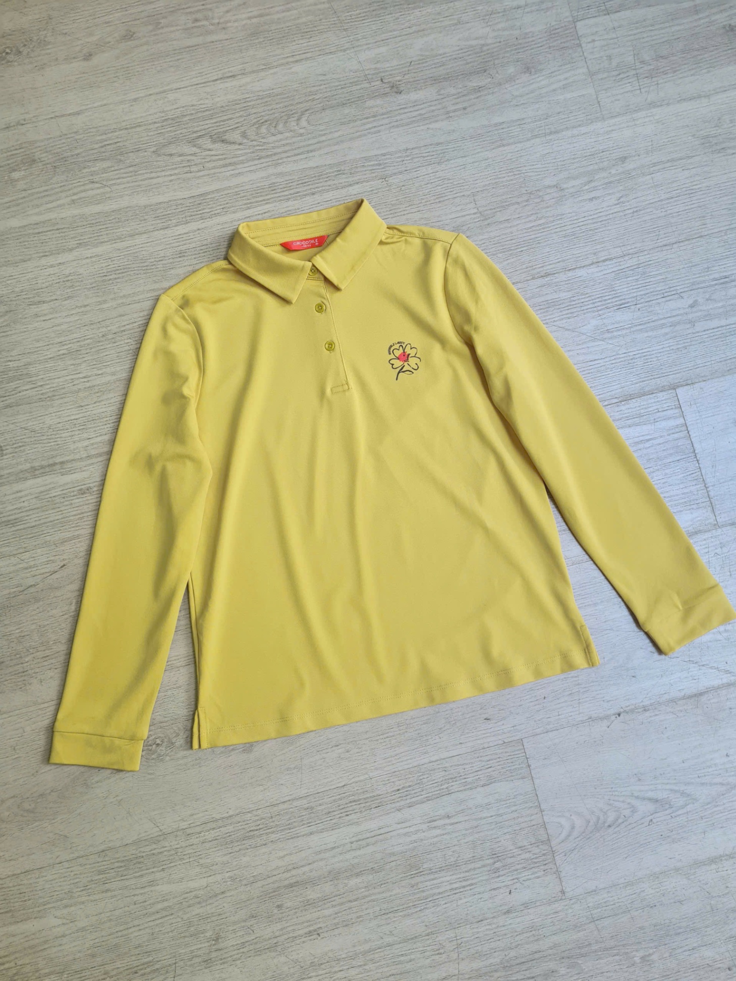 Áo polo dài tay, cài 3 cúc cổ, cành hoa nhỏ trước ngực