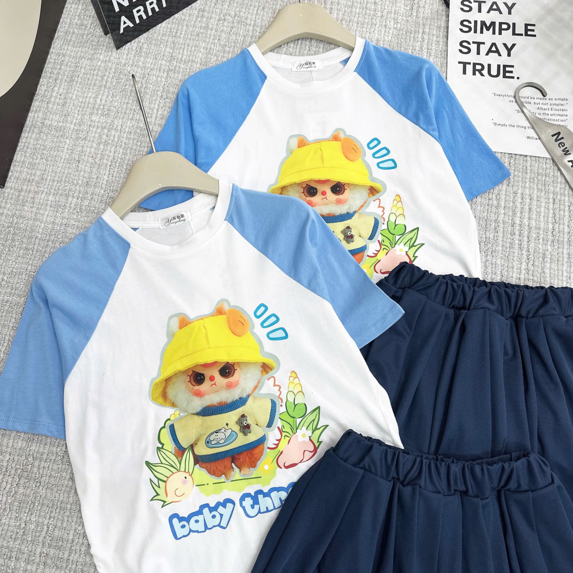 Bộ babythree đội mũ vàng áo trắng phối tay xanh chân váy xếp ly