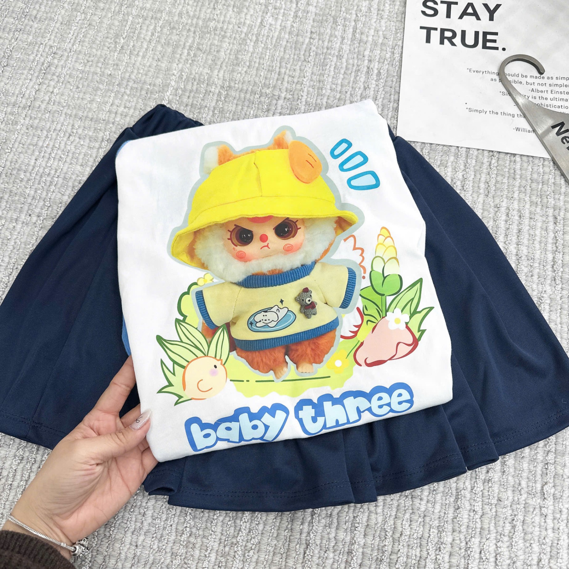 Bộ babythree đội mũ vàng áo trắng phối tay xanh chân váy xếp ly