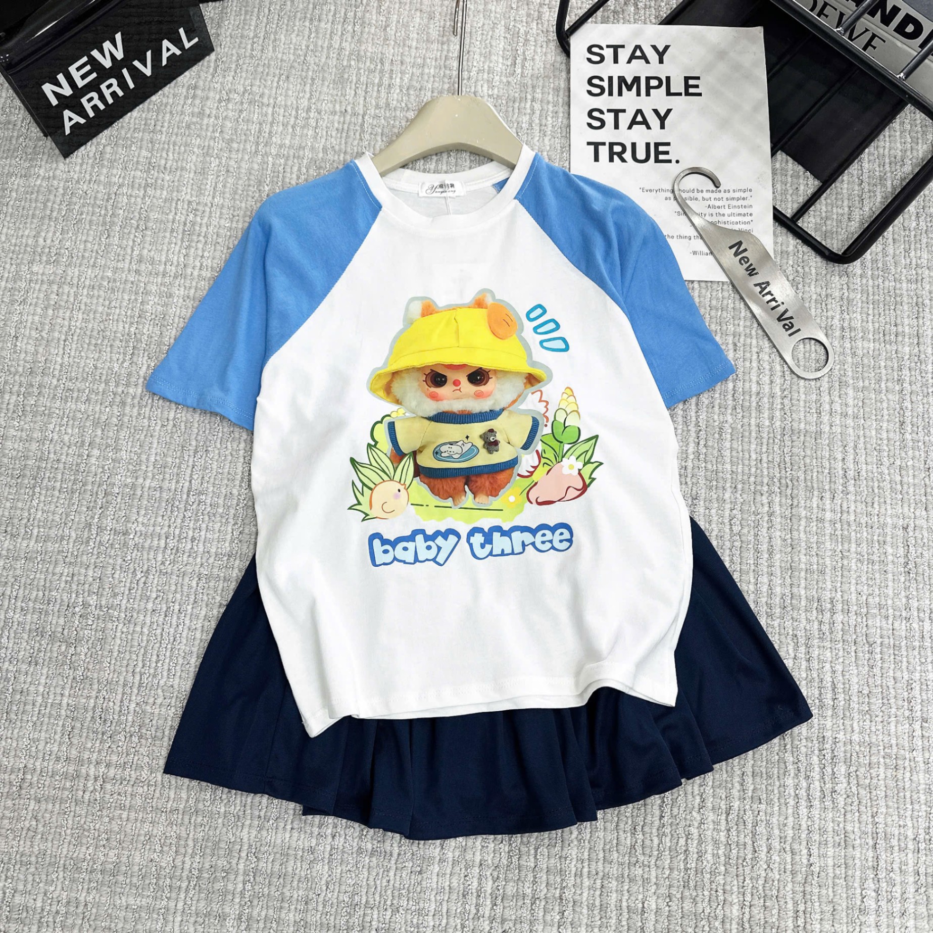 Bộ babythree đội mũ vàng áo trắng phối tay xanh chân váy xếp ly