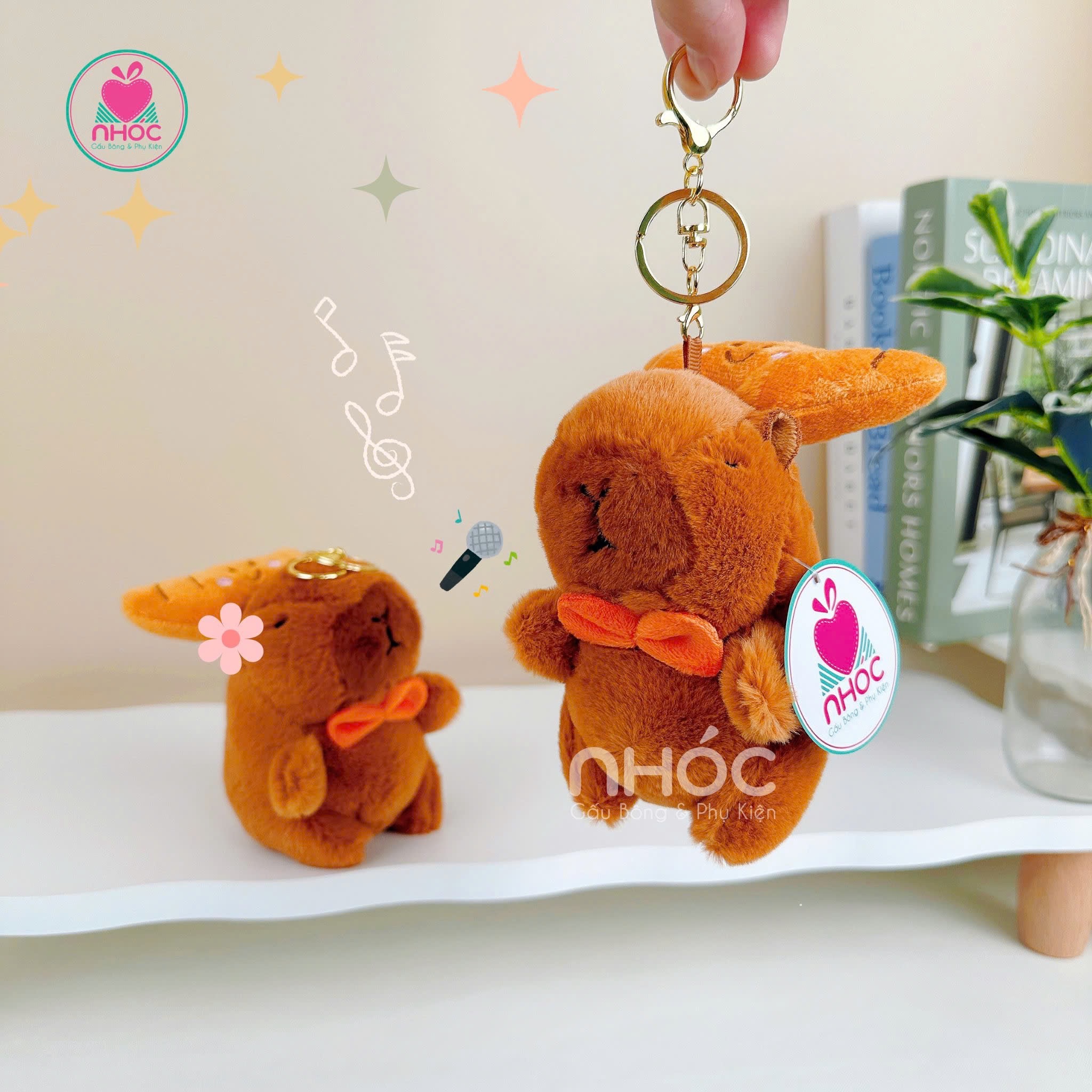 Móc khoá bông Capybara đeo nơ kéo bánh - 1095