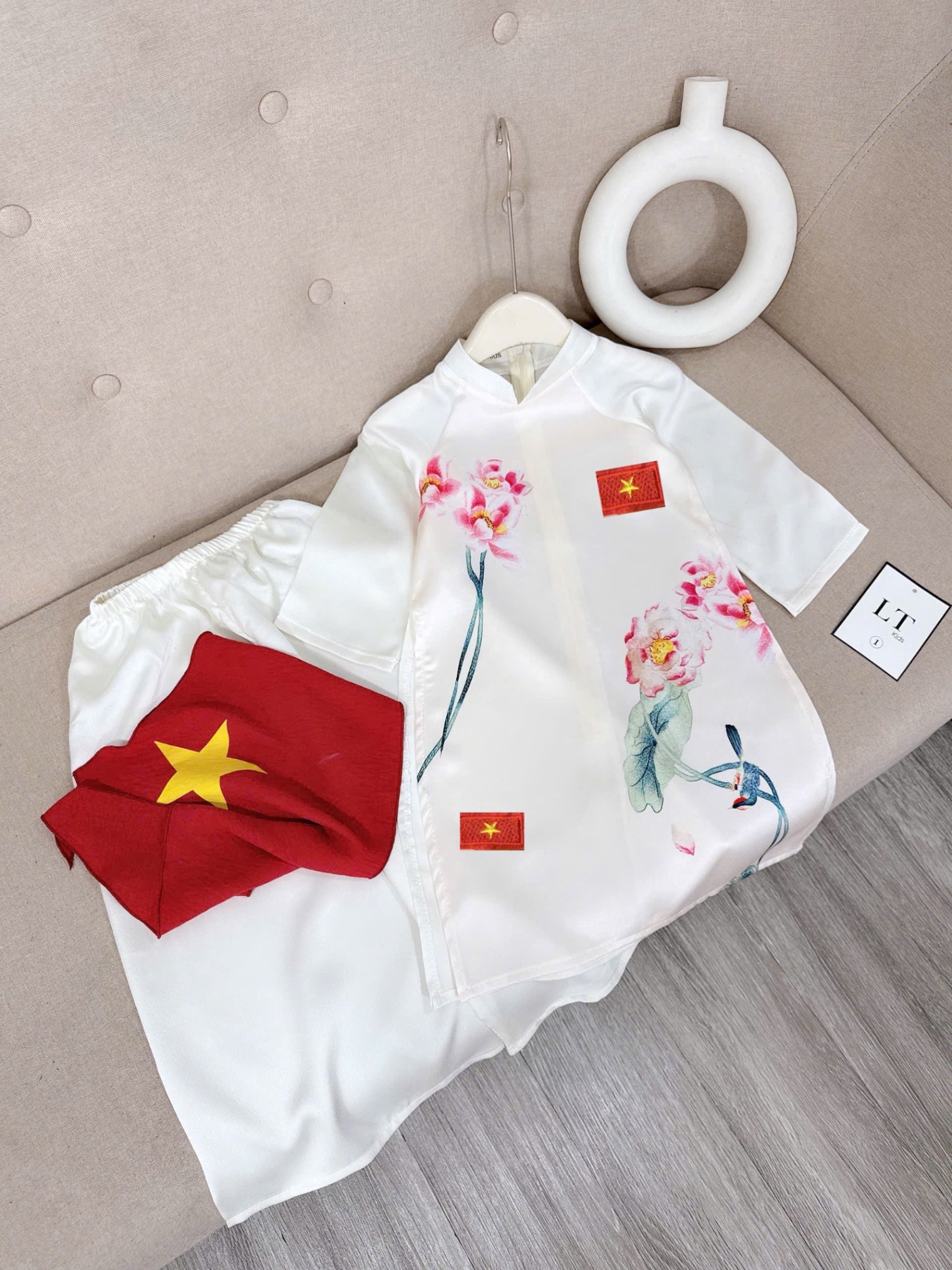 Áo dài lụa kèm cài huy hiệu và khăn bé gái